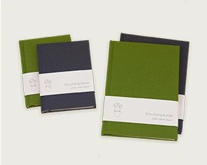 Verschiedene Ausführungen des Wochenplaners in grünem und grauem Leinen