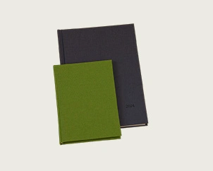 Grüner und grauer Wochenplaner aufeinanderliegend